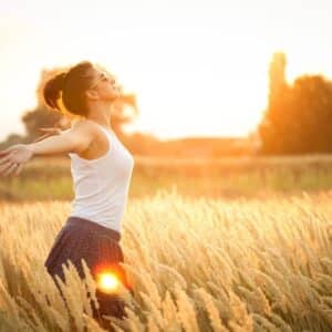 Woman running in field achieving stress relief