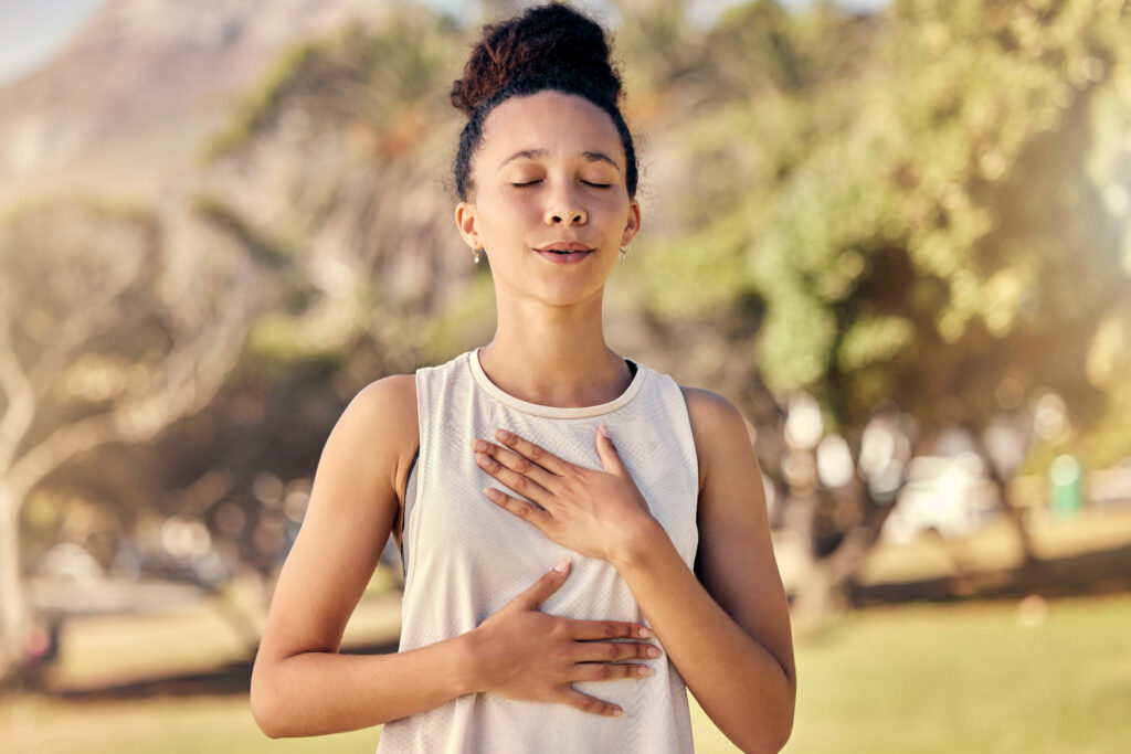 Woman practicing mindful breathing while reflecting on the past and focusing on mental health to break the cycle