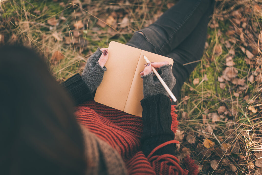 Person practicing gratitude by journaling outdoors to support mental health and physical health