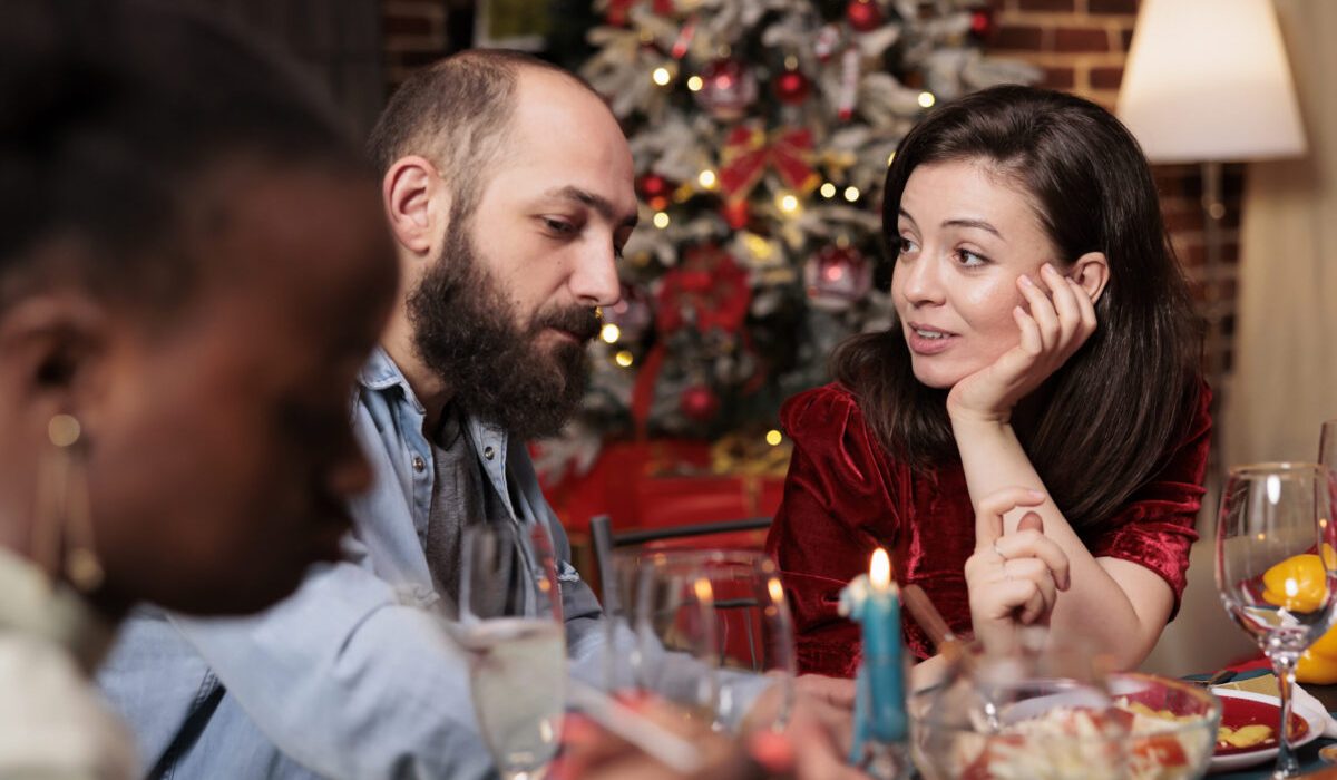 Family sharing a meaningful conversation starter at a holiday dinner while practicing mental health strategies for family health